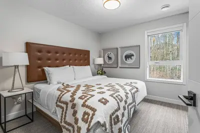 a bedroom with a large bed and a window at Spacious 3BR Haven in Scenic Canmore in Canmore