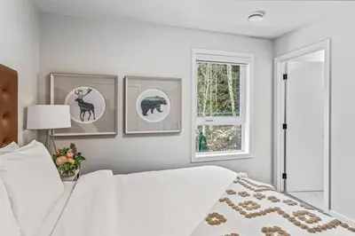 a bedroom with a white bed and three pictures on the wall at Spacious 3BR Haven in Scenic Canmore in Canmore