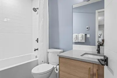 a white bathroom with a toilet and a sink at Spacious 3BR Haven in Scenic Canmore in Canmore