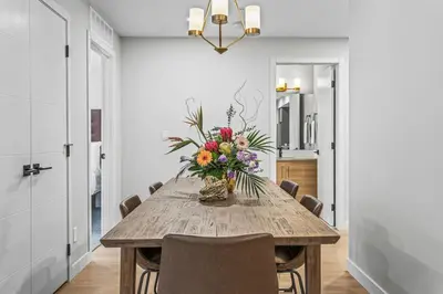 a dining room with a table with a vase of flowers at Spacious 3BR Haven in Scenic Canmore in Canmore