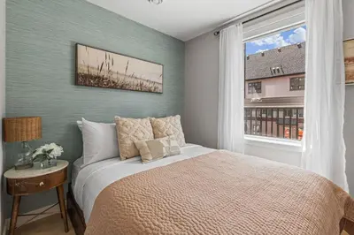 a bedroom with a large bed and a window at New 3BR with Mountain Views Near DT Hot Tub and Pool in Canmore