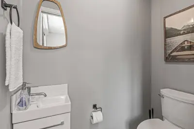 a white bathroom with a sink and a mirror at New 3BR with Mountain Views Near DT Hot Tub and Pool in Canmore