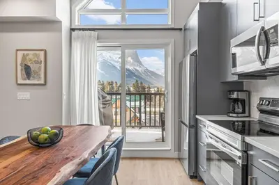 a kitchen with a table and a view of a mountain at 3BR with Stunning Views Self Check-In and Free Parking in Canmore