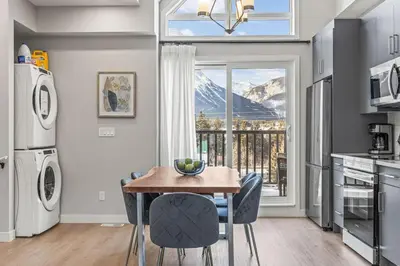 a kitchen with a table and chairs and a window at 3BR with Stunning Views Self Check-In and Free Parking in Canmore