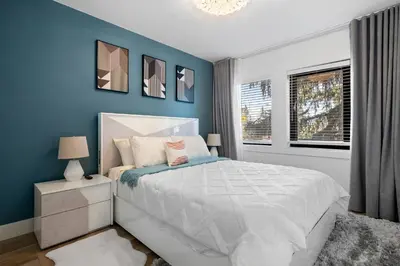 a bedroom with a white bed and blue walls at *One of a Kind* | Hot Tub| Air Hockey| Pool and… in Calgary