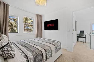 a bedroom with a bed and a clock on the wall at *One of a Kind* | Hot Tub| Air Hockey| Pool and… in Calgary