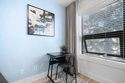 a small desk in a room with a window at *One of a Kind* | Hot Tub| Air Hockey| Pool and… in Calgary
