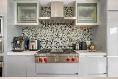 a kitchen with a stove top oven in a kitchen at *Spectacular* Sauna |Rocket-ship|Game-Room|Hammock in Calgary