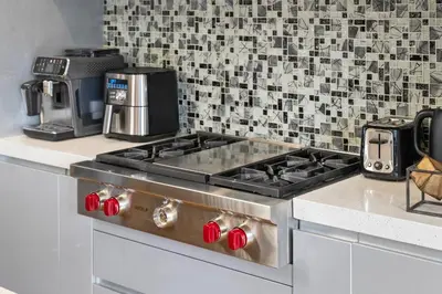 a kitchen with a stove top with a coffee maker at *Spectacular* Sauna |Rocket-ship|Game-Room|Hammock in Calgary
