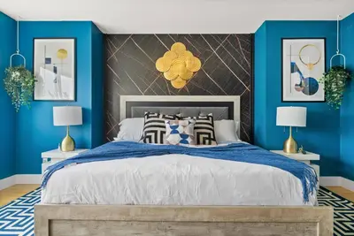 a bedroom with blue walls and a large bed at *Spectacular* Sauna |Rocket-ship|Game-Room|Hammock in Calgary