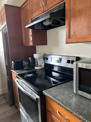 a kitchen with a stove and a refrigerator at Luxurious & Spacious 4-Bedroom Vacation Home in Edmonton