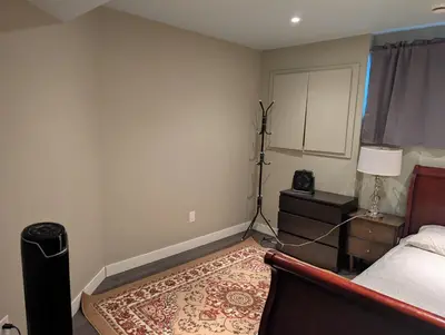 a bedroom with a bed and a table with a lamp at 2-Room Suite in South Edmonton in Edmonton