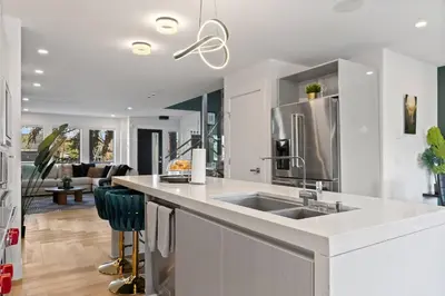 a kitchen with a sink and a living room at *Everything*| Hot Tub| Sauna| Pool table|Game Room in Calgary