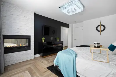 a bedroom with a fireplace and a bed at *Everything*| Hot Tub| Sauna| Pool table|Game Room in Calgary