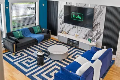 a living room with a couch and a tv at *Everything*| Hot Tub| Sauna| Pool table|Game Room in Calgary