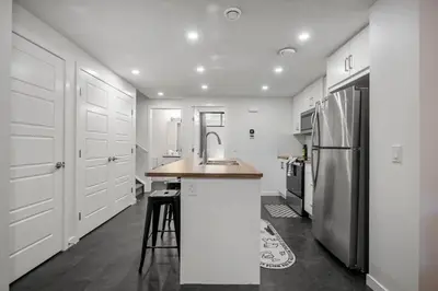 a kitchen with a sink and a refrigerator at Modern Suburban Retreat in Ambleton Stylish Comfort Near Parks and Trails in Calgary