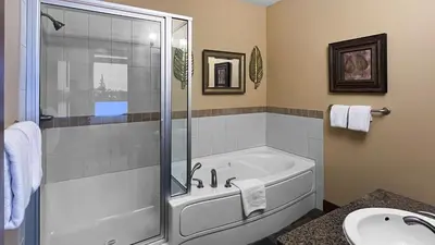 a bathroom with a shower and a tub and a sink at Stonegate Resort Unit C403 in Big White