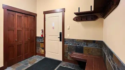 a hallway with two wooden doors and a stone fireplace at Stonegate Resort Unit C403 in Big White