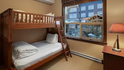 a bedroom with two bunk beds and a window at Stonegate Resort Unit C403 in Big White