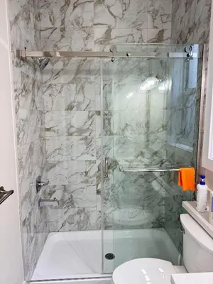 a bathroom with a shower with a glass door at Excellent Place to Stay in Coquitlam