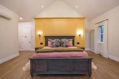 a bedroom with a large bed with a wooden headboard at Samson House in Revelstoke