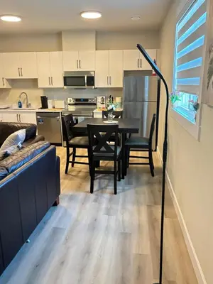 a living room and kitchen with a table and chairs at Prince George Cozy Suite in Prince George