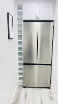 a stainless steel refrigerator in a kitchen with empty shelves at Ivey Homes in Edmonton