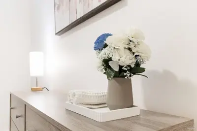 a vase filled with white and blue flowers on a table at Lynn Valley 2BR Suite By Grouse Mtn & Lynn Canyon in North Vancouver