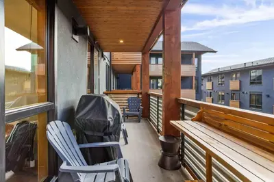 a balcony with chairs and a bench on a building at Creekside Cove in Spring Creek in Canmore