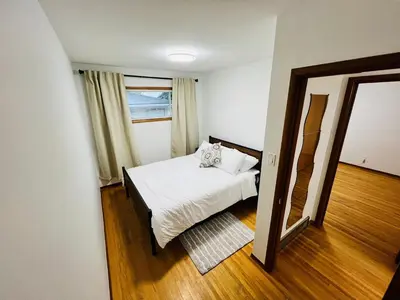 a small bedroom with a bed and a mirror at mysev property in Calgary