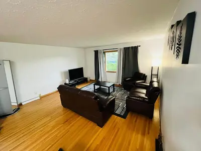 a living room with two leather chairs and a television at mysev property in Calgary