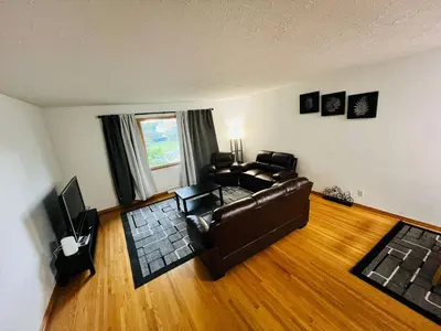 a living room with a leather couch and a television at mysev property in Calgary