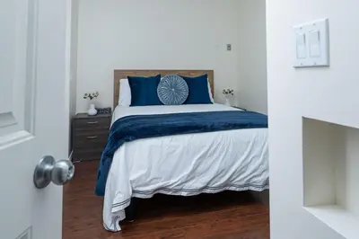 a bedroom with a bed with blue and white sheets at Northern Solace, 2 beds, 2 baths, 5 min to airport in Yellowknife