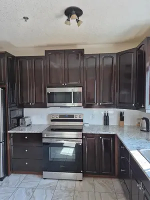 a kitchen with wooden cabinets and a stove top oven at Northern Solace, 2 beds, 2 baths, 5 min to airport in Yellowknife