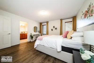 a bedroom with a large bed with white sheets at 6BDRM Chic Modern Home-Fireplace-BBQ-Sleeps 18! in Edmonton