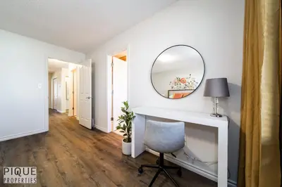 a room with a desk with a mirror and a chair at 6BDRM Chic Modern Home-Fireplace-BBQ-Sleeps 18! in Edmonton