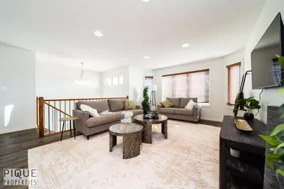 a living room with a couch and a table at 6BDRM Chic Modern Home-Fireplace-BBQ-Sleeps 18! in Edmonton