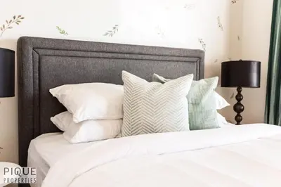 a bedroom with a bed with white pillows at 6BDRM Chic Modern Home-Fireplace-BBQ-Sleeps 18! in Edmonton