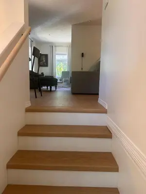 a stairway leading to a living room with a piano at Lake Trail Guesthouse in Victoria