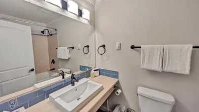 a bathroom with a sink and a toilet and a mirror at Rocky Mountain Condos by StayIn in Kimberley