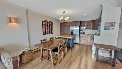 a kitchen with a wooden table and a dining room at Rocky Mountain Condos by StayIn in Kimberley