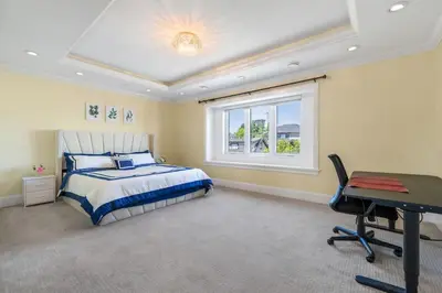a bedroom with a bed and a desk and a window at Luxury 4-Bedroom Villa in Vancouver