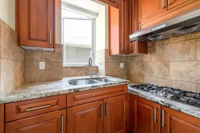 a kitchen with wooden cabinets and a sink and a window at Luxury 4-Bedroom Villa in Vancouver