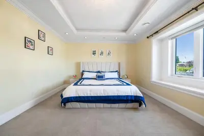 a bedroom with a bed in a room with a window at Luxury 4-Bedroom Villa in Vancouver