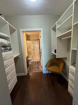 a room with a walk in closet with a chair at Peaceful Condo for Short and Long Term Rental in Edmonton