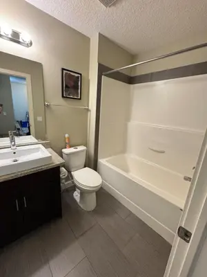 a bathroom with a toilet and a tub and a sink at Peaceful Condo for Short and Long Term Rental in Edmonton