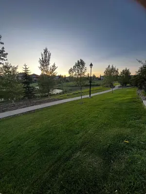 a park with a grass field and a sidewalk at Peaceful Condo for Short and Long Term Rental in Edmonton
