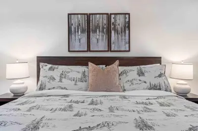 a bedroom with a large bed with two lamps at 2BR in Symphony, Hot Tub, Gas Fireplace, Epic Village Location, Ski Shuttle in Whistler