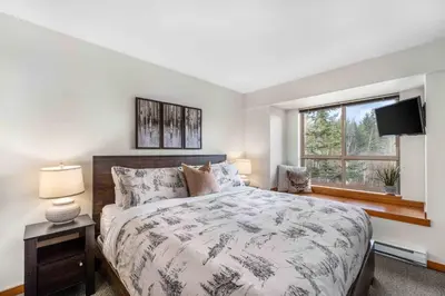 a bedroom with a large bed and a window at 2BR in Symphony, Hot Tub, Gas Fireplace, Epic Village Location, Ski Shuttle in Whistler