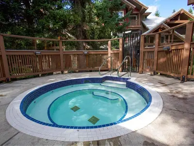 a swimming pool in a backyard with a wooden fence at 2BR in Symphony, Hot Tub, Gas Fireplace, Epic Village Location, Ski Shuttle in Whistler